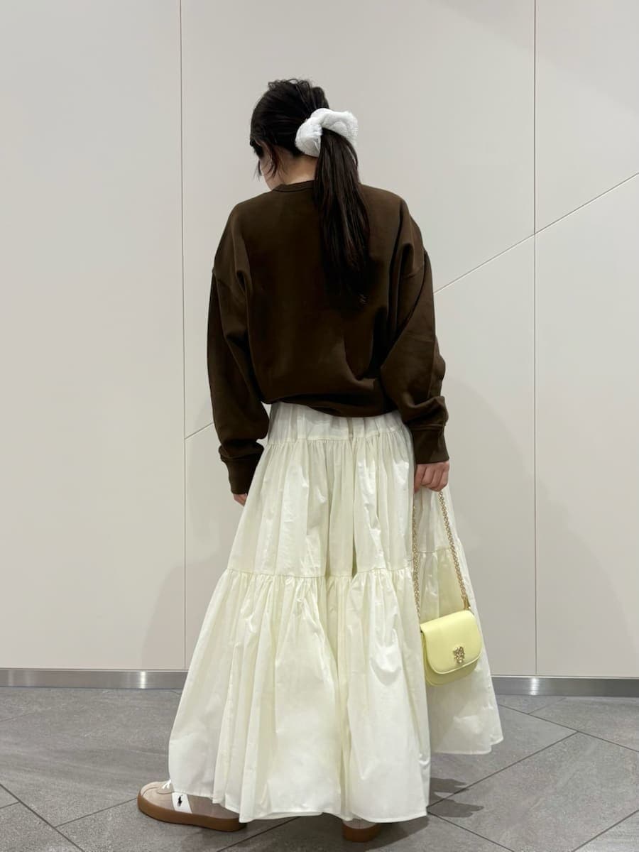 ホワイト系のスカート、ブラウン系のスウェット、イエロー系のショルダーバッグを着用したレディースの春コーディネートの4枚目の写真