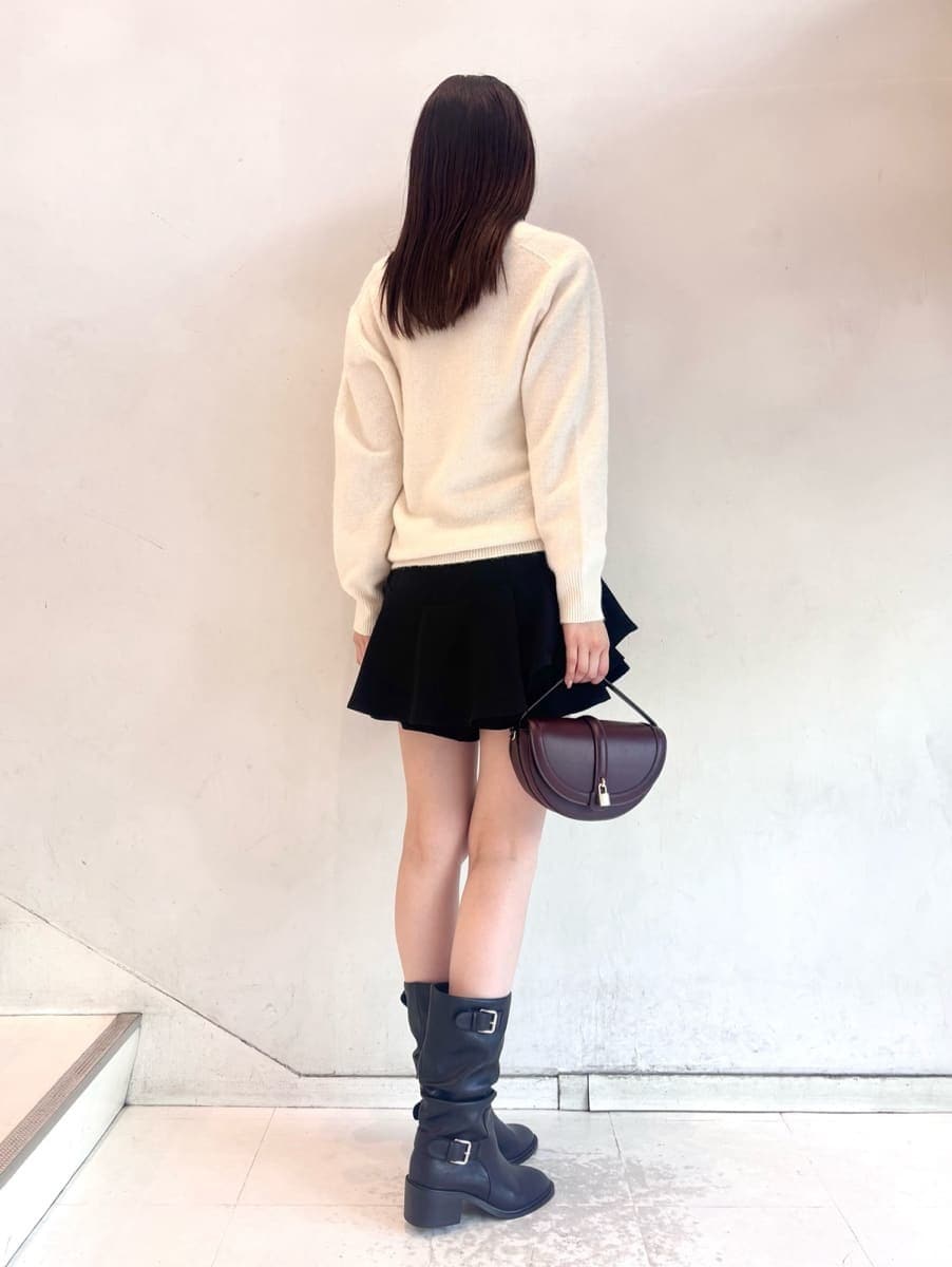 ブラウン系のハンドバッグ、ホワイト系のニット/セーター、ブラック系のその他パンツを着用したレディースの秋コーディネートの4枚目の写真