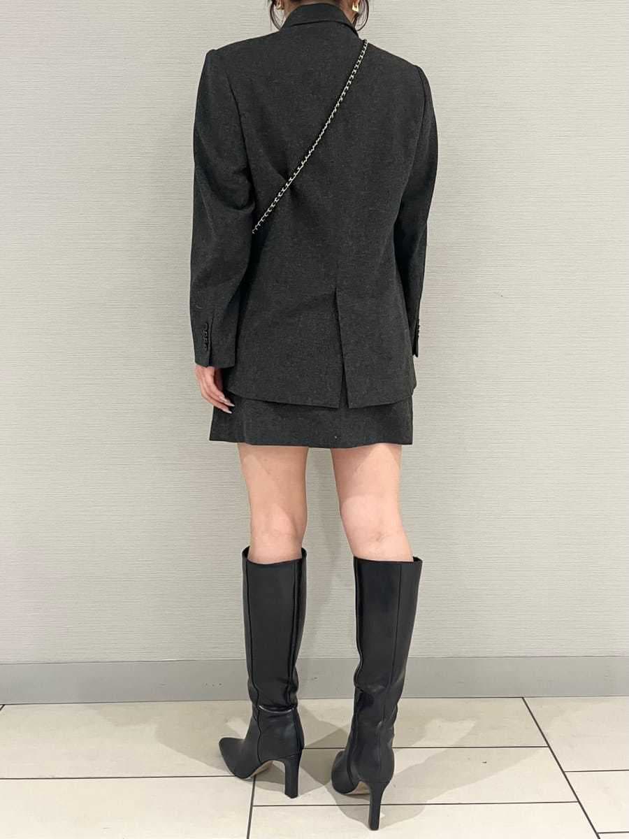 グレー系のテーラードジャケット、グレー系のワンピース、ブラック系のブーツを着用したレディースの秋コーディネートの3枚目の写真