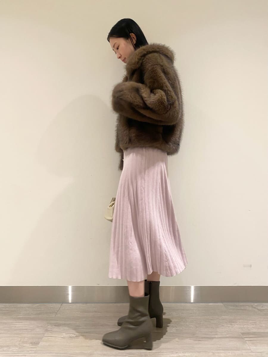 ブラウン系のチェスターコート、ピンク系のワンピース、ホワイト系のボストンバッグを着用したレディースの秋コーディネートの2枚目の写真