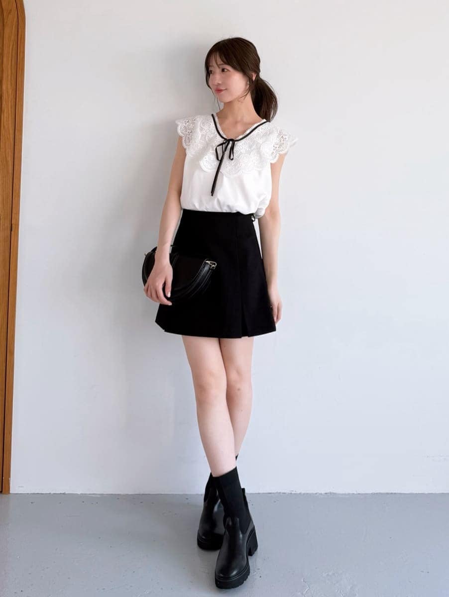 ホワイト系のシャツ/ブラウス、ブラック系のスカート、ブラック系のハンドバッグを着用したレディースの夏コーディネートの2枚目の写真