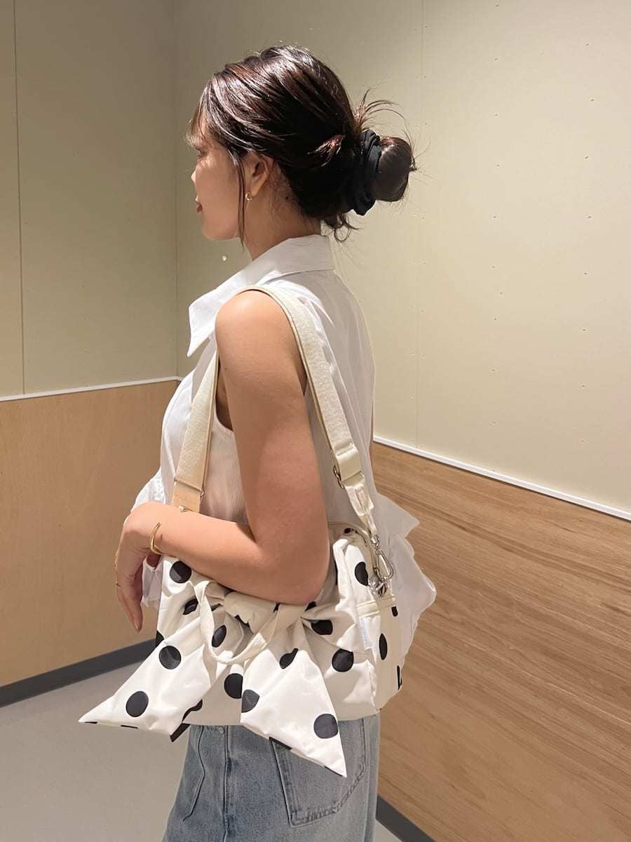 ブルー系のデニムパンツ、ホワイト系のシャツ/ブラウス、ホワイト系のショルダーバッグを着用したレディースの夏コーディネートの6枚目の写真
