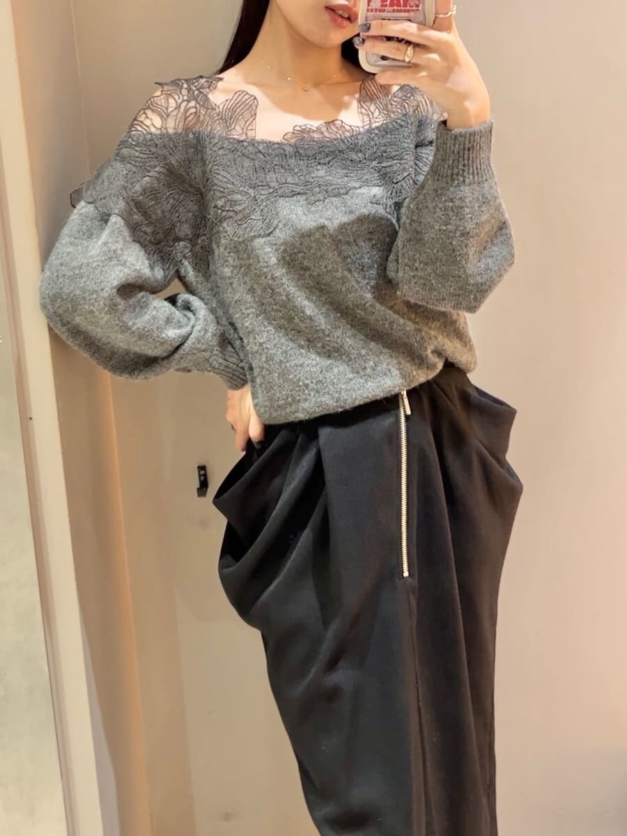 グレー系のニット/セーター、ブラック系のスカート、ブラック系のハンドバッグを着用したレディースの秋コーディネートの6枚目の写真