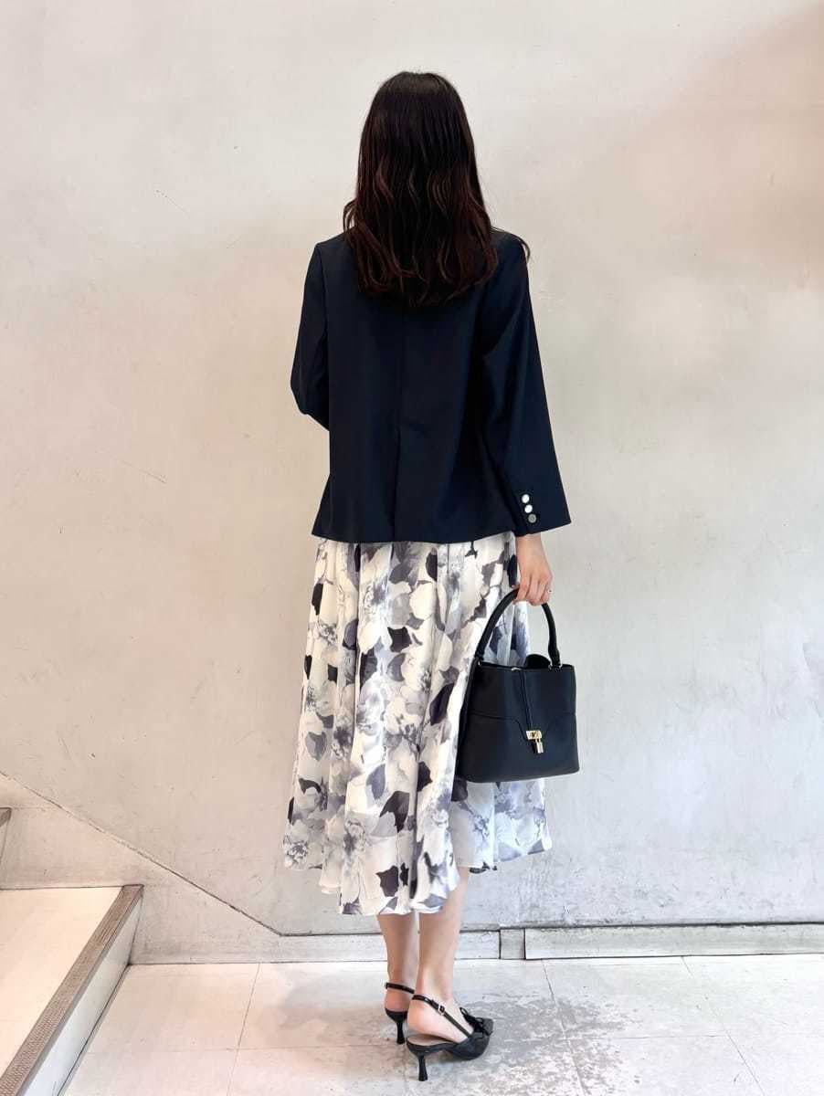 ブルー系のワンピース、ブルー系のテーラードジャケット、ブラック系のショルダーバッグを着用したレディースの秋コーディネートの5枚目の写真