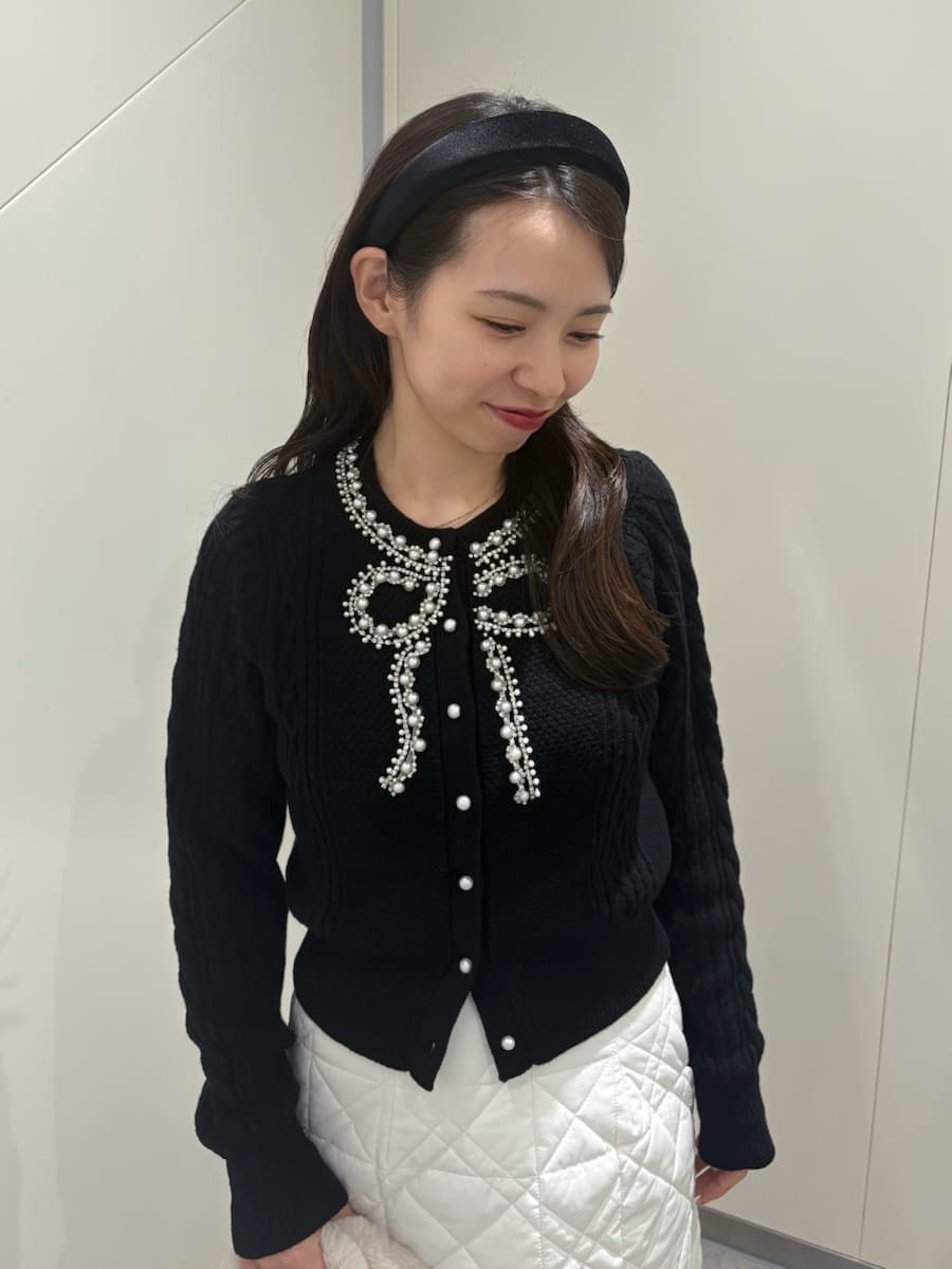 ホワイト系のスカート、ブラック系のニット/セーター、ブラック系のブーツを着用したレディースの秋コーディネートの6枚目の写真