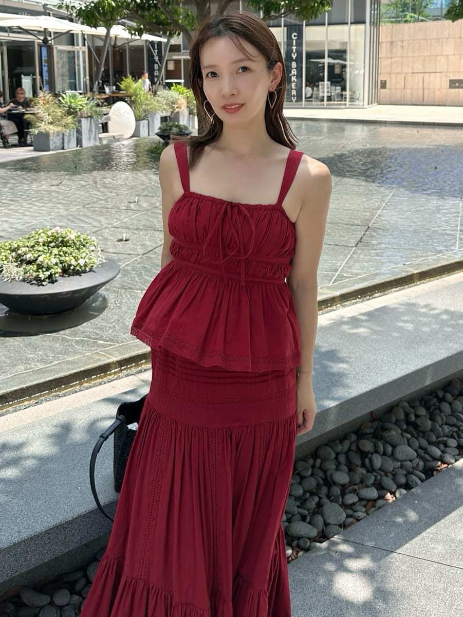 レッド系のスカート、レッド系のシャツ/ブラウス、ゴールド系のピアス（両耳用）を着用したレディースの夏コーディネートの4枚目の写真