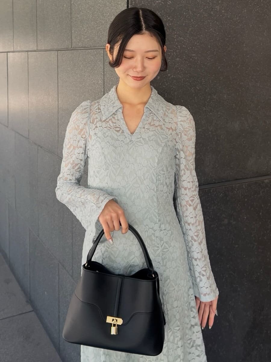 ブラック系のブーツ、グリーン系のワンピース、ブラック系のハンドバッグを着用したレディースの冬コーディネートの4枚目の写真