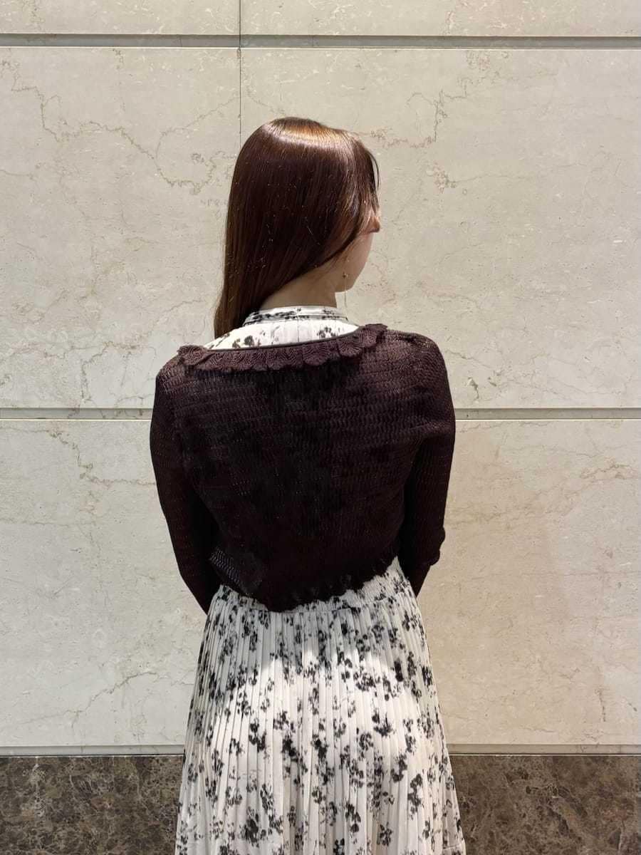 ベージュ系のワンピース、ホワイト系のカーディガン/ボレロ、ブラウン系のパンプスを着用したレディースの冬コーディネートの6枚目の写真