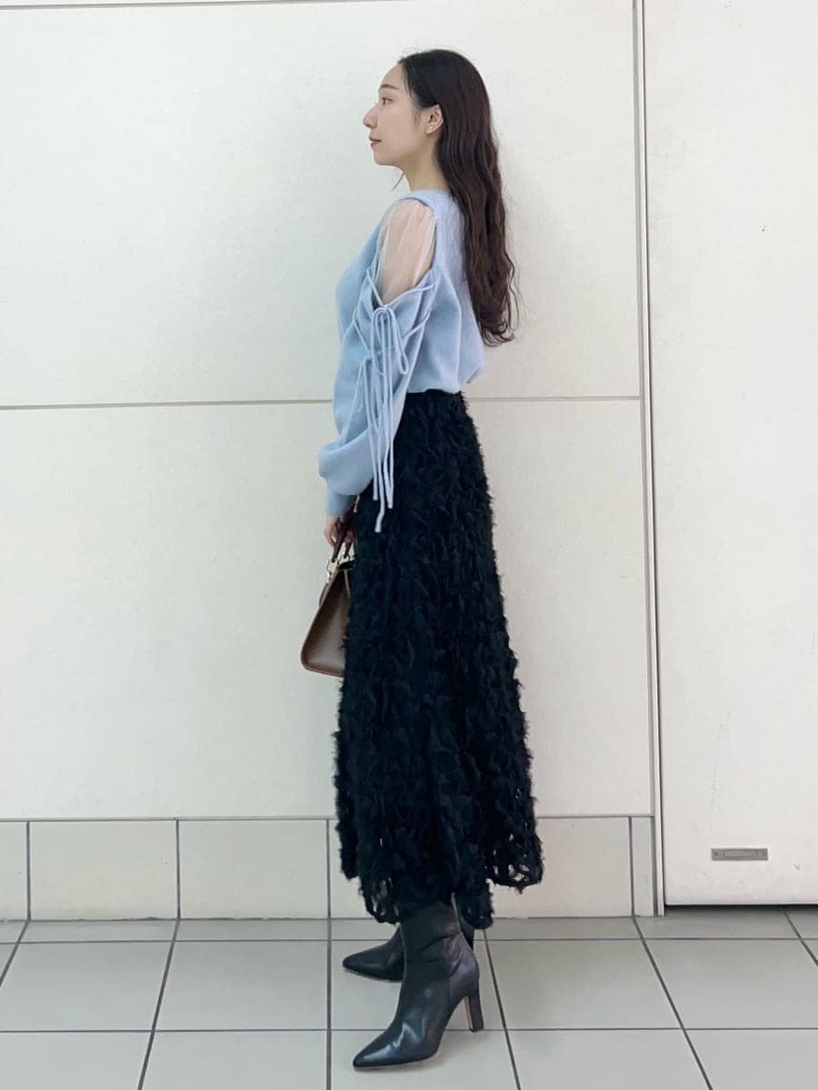 ブラック系のブーツ、ブラック系のスカート、ブルー系のニット/セーターを着用したレディースの冬コーディネートの3枚目の写真