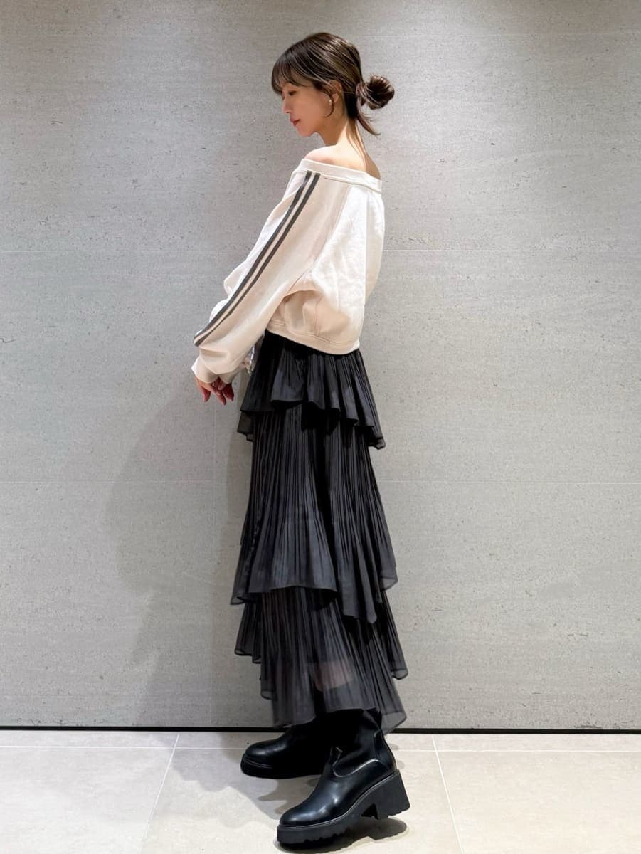 グレー系のスカート、ピンク系のスウェット、その他のイヤリングを着用したレディースの秋コーディネートの2枚目の写真