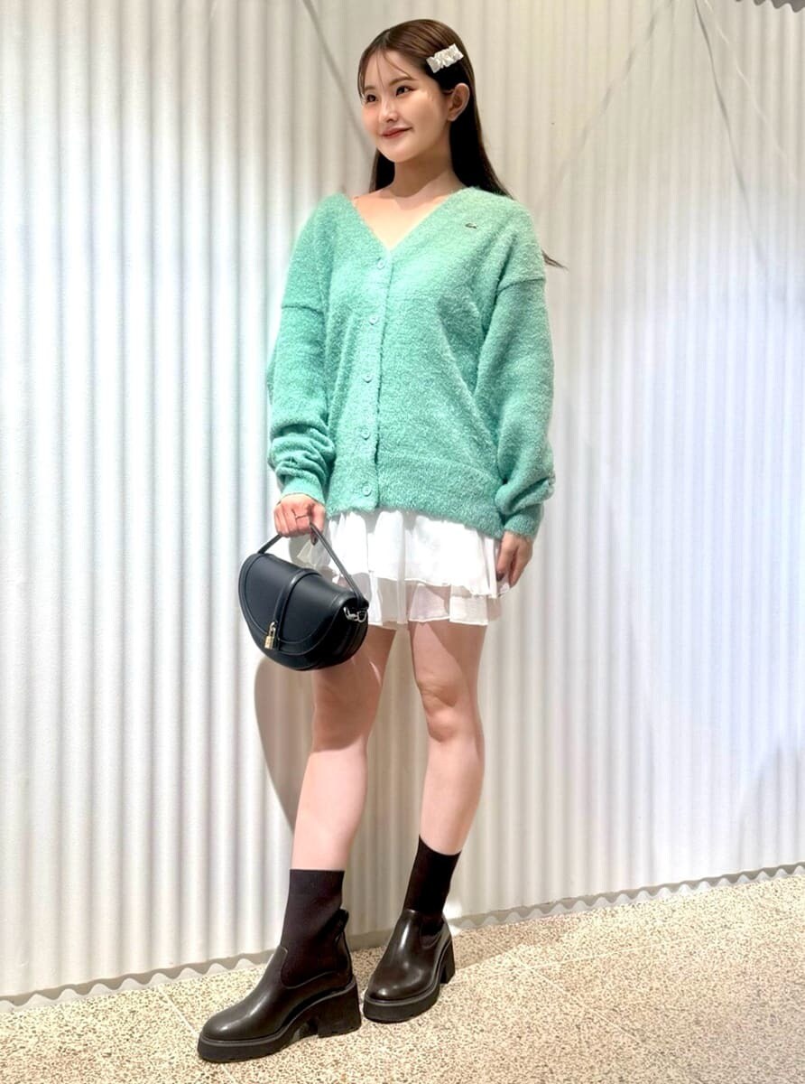 グリーン系のカーディガン/ボレロ、ホワイト系のその他パンツ、ブラック系のハンドバッグを着用したレディースの秋コーディネートの4枚目の写真