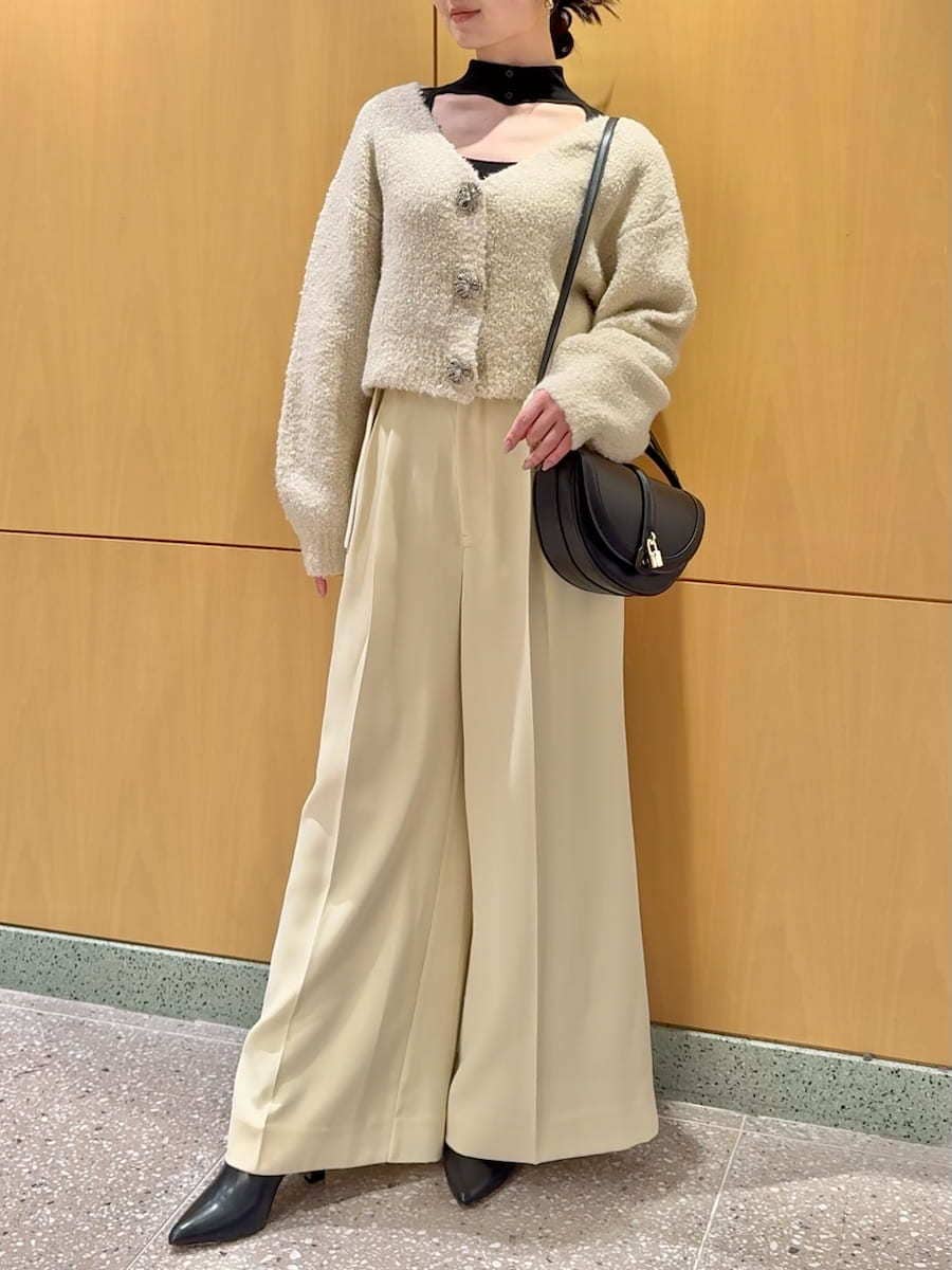 ホワイト系のカーディガン/ボレロ、ブラック系のニット/セーター、ブラック系のブーツを着用したレディースの秋コーディネートの6枚目の写真