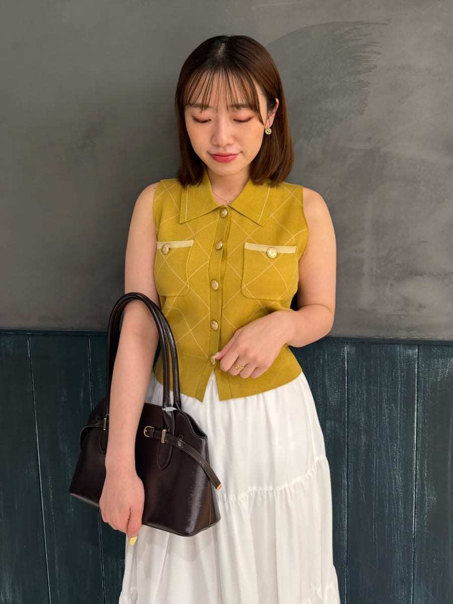 イエロー系のワンピース、ブラウン系のサンダル、ブラウン系のボストンバッグを着用したレディースの夏コーディネートの5枚目の写真