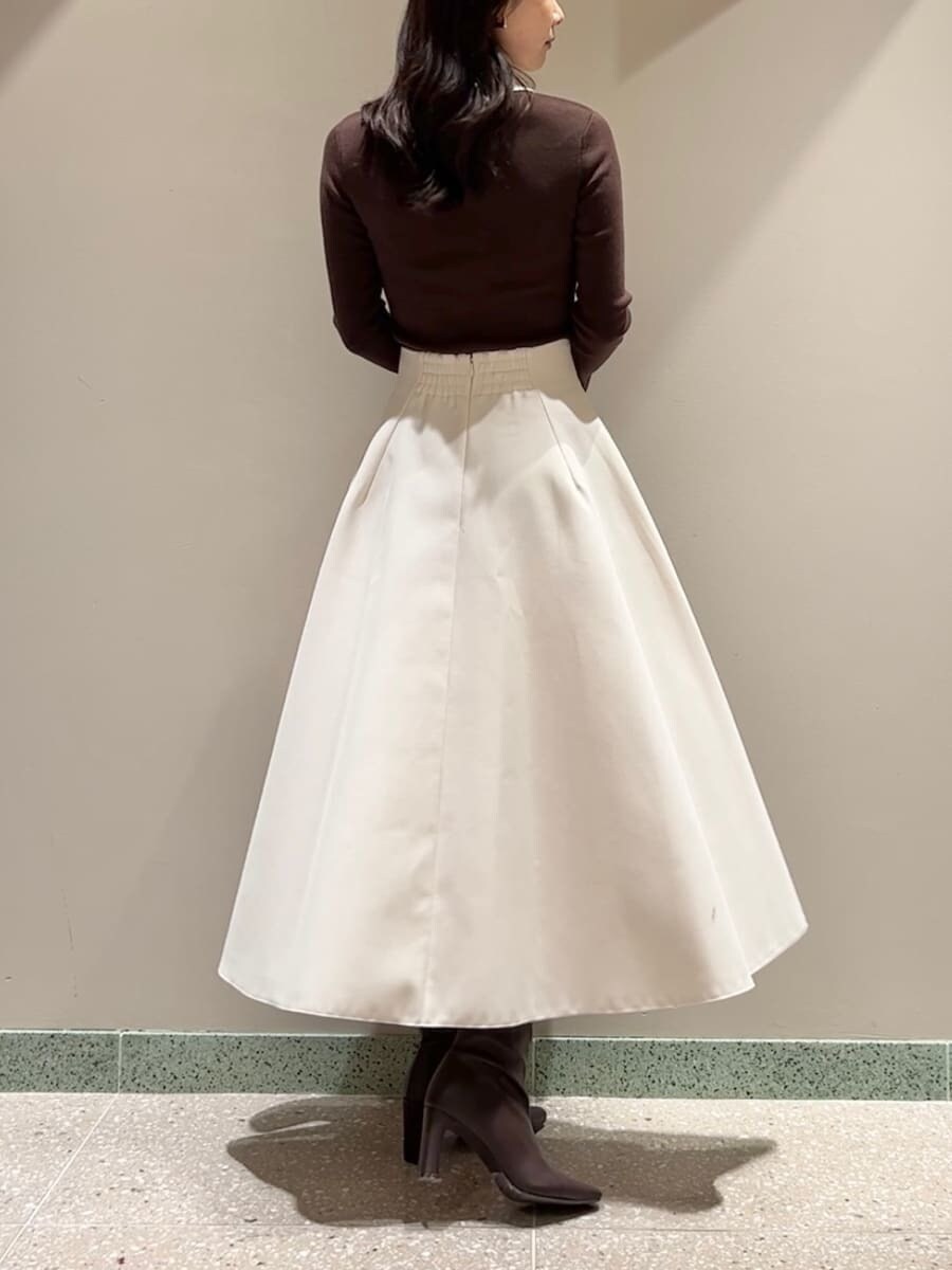 レッド系のブーツ、ブラウン系のニット/セーター、ブラウン系のハンドバッグを着用したレディースの冬コーディネートの3枚目の写真