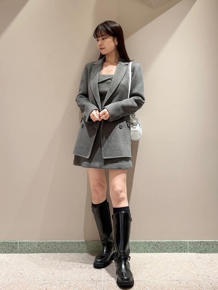 ブラック系のブーツ、グレー系のテーラードジャケット、グレー系のワンピースを着用したレディースの秋コーディネートの4枚目の写真