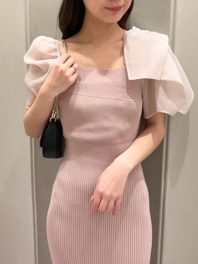 ピンク系のワンピース、ブラック系のパンプス、ブラック系のショルダーバッグを着用したレディースの春コーディネートの6枚目の写真