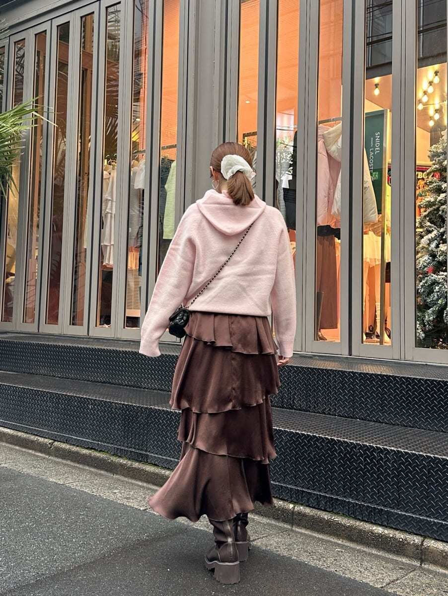 ピンク系のニット/セーター、ブラウン系のスカート、ブラック系のショルダーバッグを着用したレディースの秋コーディネートの4枚目の写真