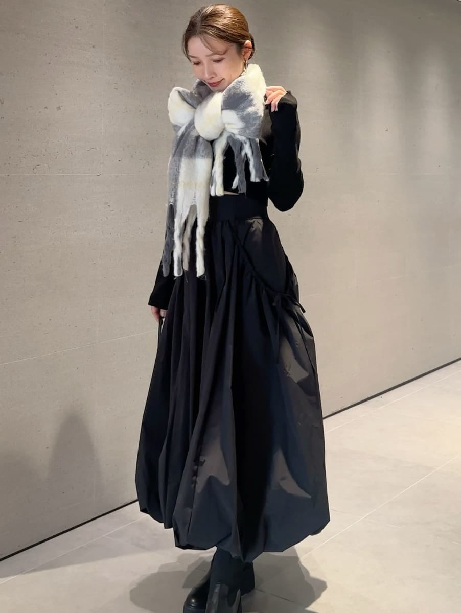 ブラック系のスカート、ブラック系のニット/セーター、グレー系のストール/ショールを着用したレディースの秋コーディネートの5枚目の写真