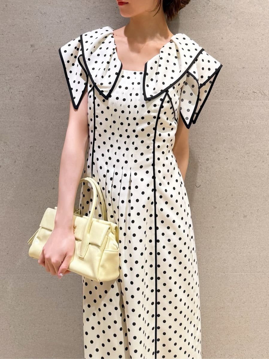 イエロー系のボストンバッグ、ホワイト系のワンピースを着用したレディースの春コーディネートの3枚目の写真