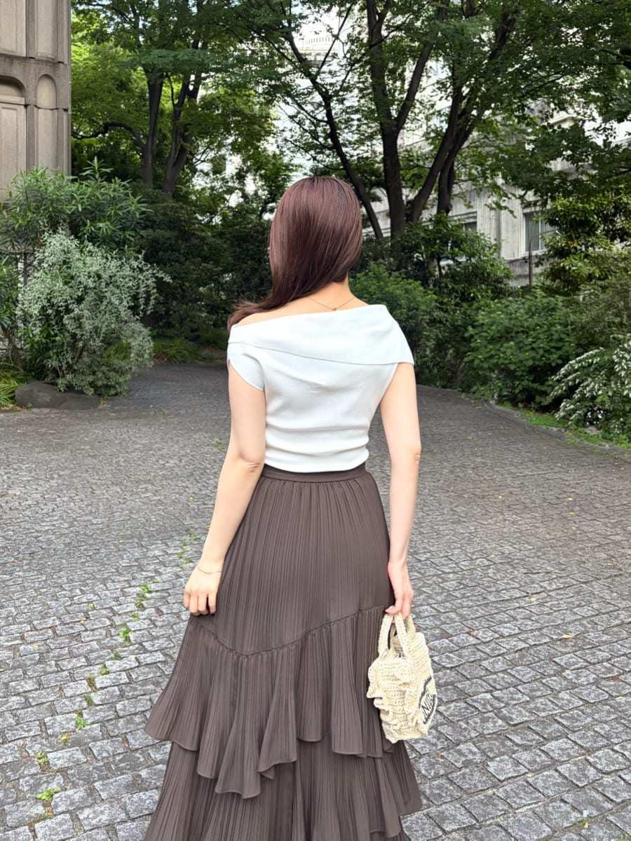 ベージュ系のショルダーバッグ、ブラウン系のスカート、ホワイト系のニット/セーターを着用したレディースの春コーディネートの6枚目の写真