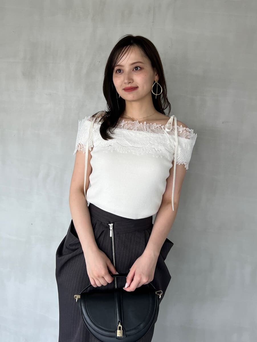 ホワイト系のニット/セーター、グレー系のスカート、ブラック系のブーツを着用したレディースの秋コーディネートの5枚目の写真