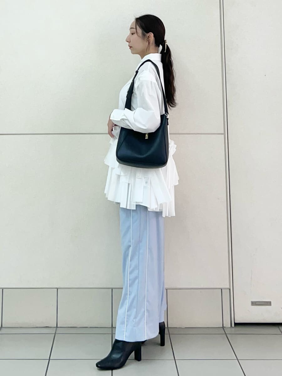 ホワイト系のワンピース、ブルー系のその他パンツ、ブラック系のブーツを着用したレディースの秋コーディネートの3枚目の写真