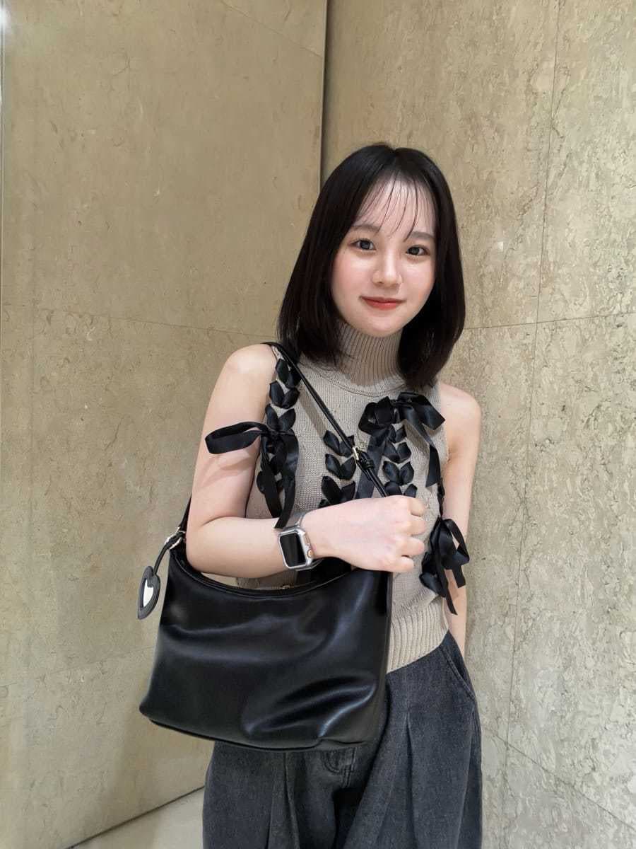ブラック系のデニムパンツ、ベージュ系のニット/セーター、ブラック系のサンダルを着用したレディースの夏コーディネートの6枚目の写真