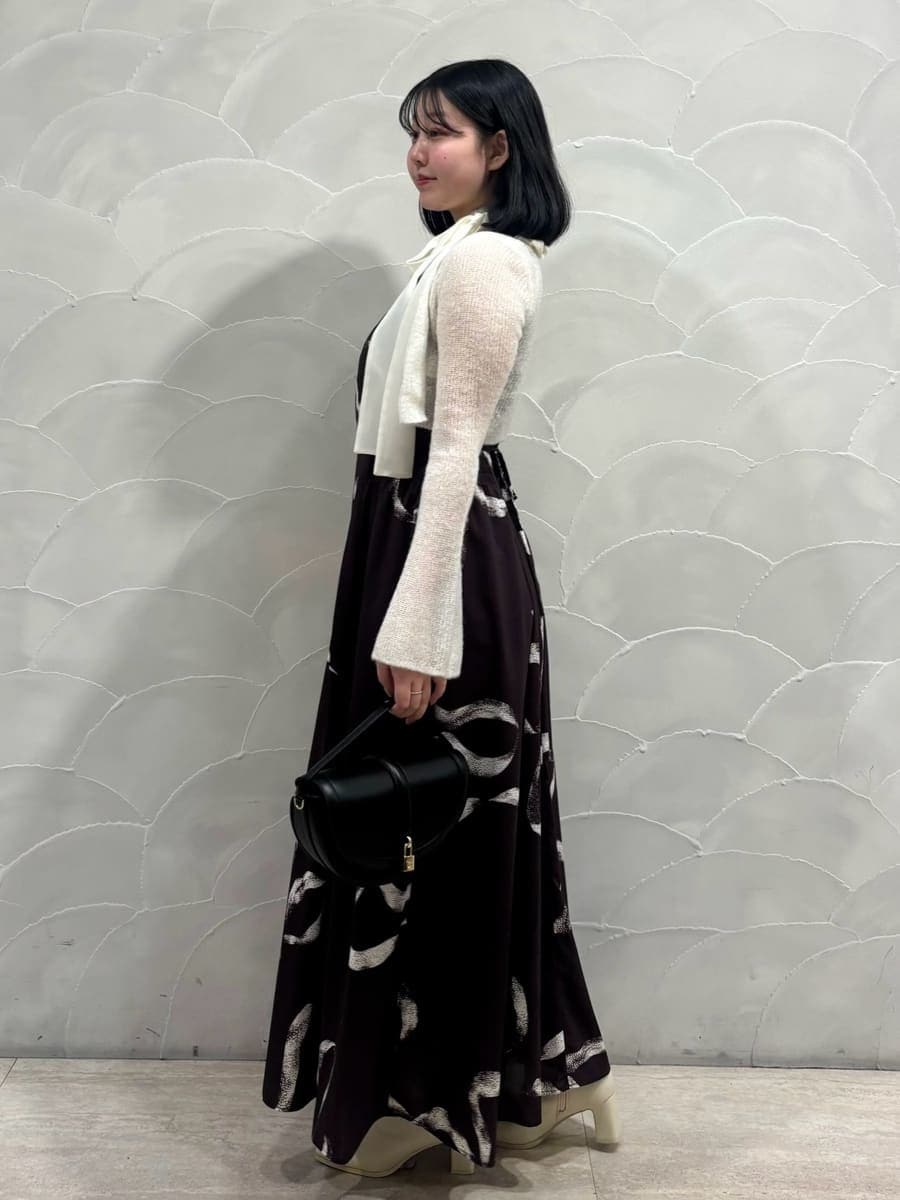 ブラック系のハンドバッグ、ブラウン系のワンピースを着用したレディースの冬コーディネートの2枚目の写真