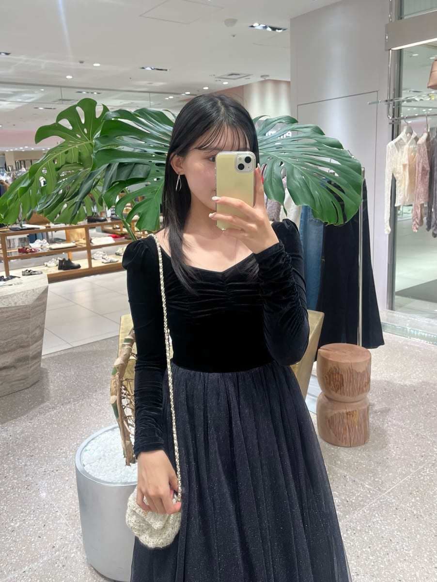 ブラック系のワンピース、ホワイト系のショルダーバッグ、ブラック系のブーツを着用したレディースの夏コーディネートの6枚目の写真