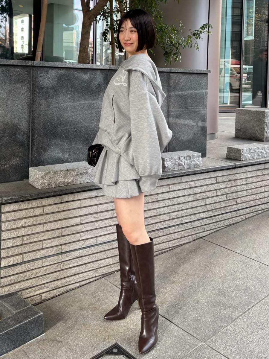 ブラウン系のブーツ、グレー系のパーカー、ブラック系のボストンバッグを着用したレディースの冬コーディネートの3枚目の写真