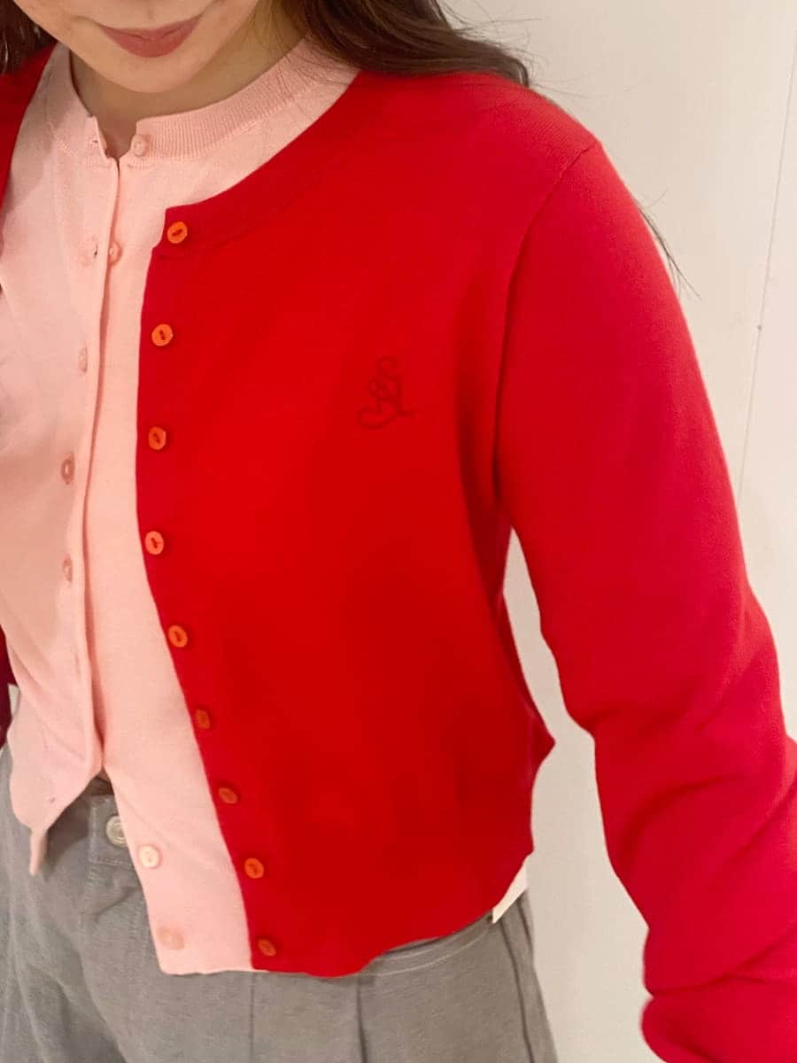 グレー系のデニムパンツ、レッド系のカーディガン/ボレロ、シルバー系のスニーカーを着用したレディースの冬コーディネートの7枚目の写真