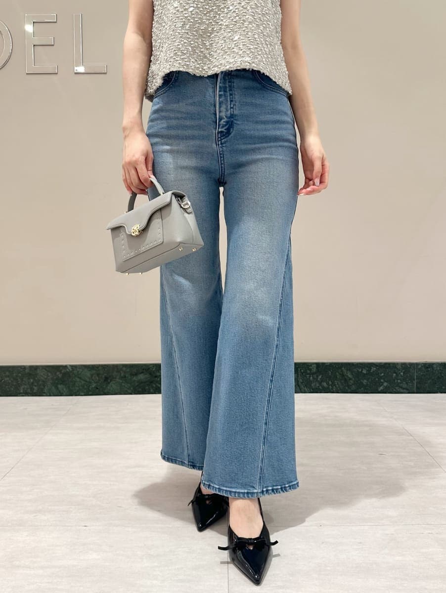 グレー系のタンクトップ、ブルー系のデニムパンツ、ブルー系のショルダーバッグを着用したレディースの夏コーディネートの3枚目の写真