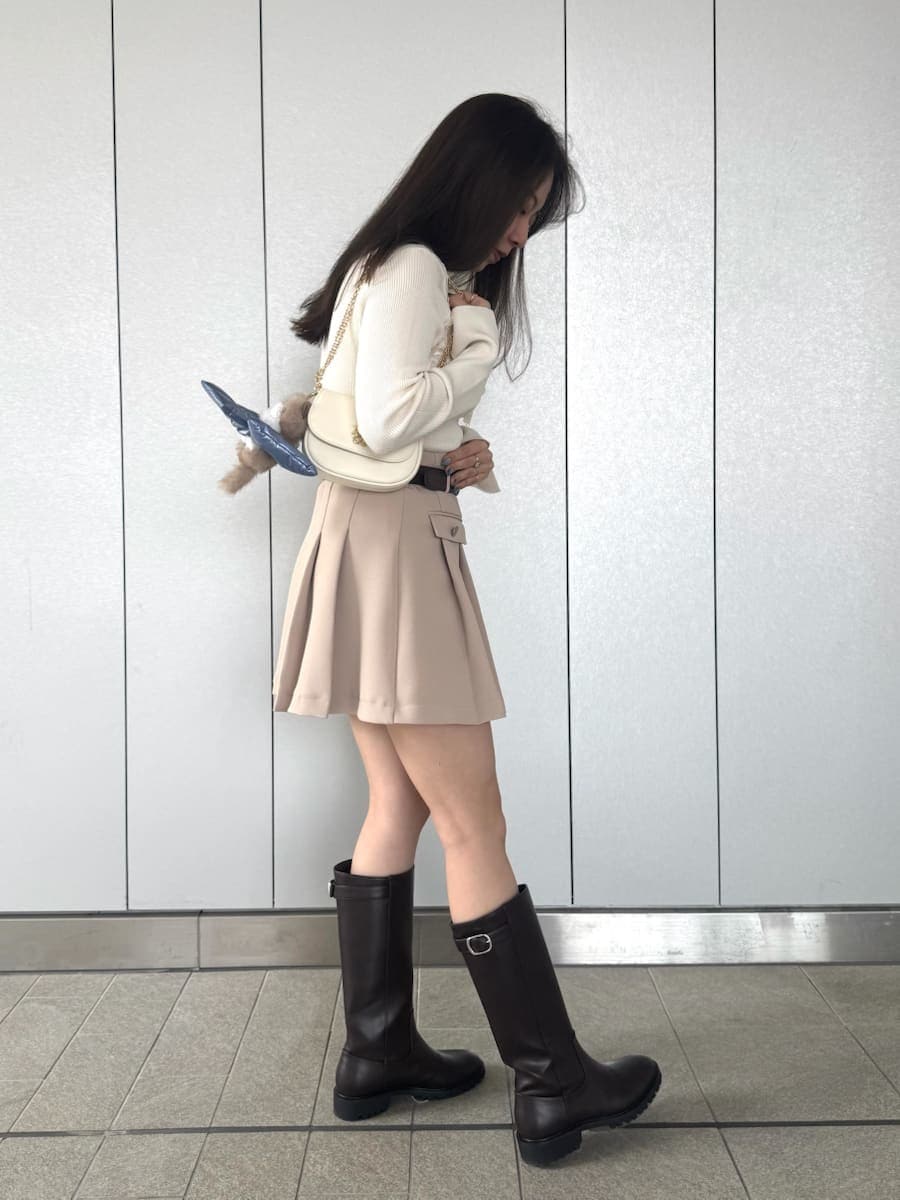 ベージュ系のスカート、ホワイト系のショルダーバッグ、ベージュ系のキーケース/キーアクセサリーを着用したレディースの冬コーディネートの2枚目の写真