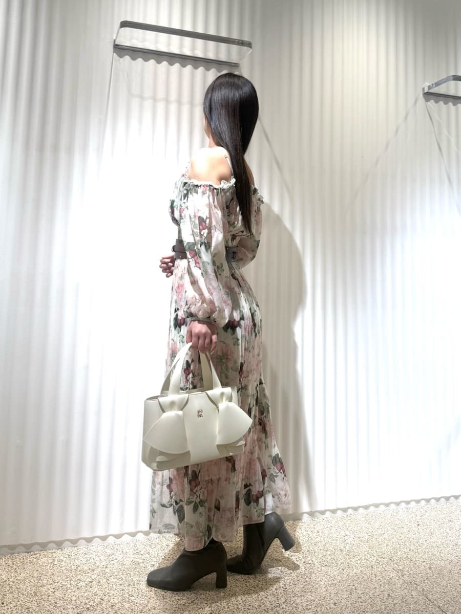 ピンク系のワンピース、ホワイト系のハンドバッグ、ブラウン系のベルトを着用したレディースの冬コーディネートの3枚目の写真