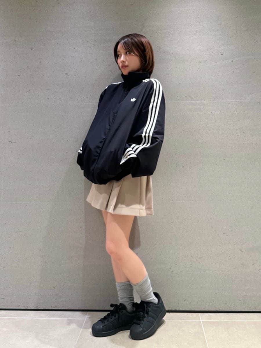 ベージュ系のスカート、ブラック系のブルゾン、ブラック系のスニーカーを着用したレディースの冬コーディネートの7枚目の写真