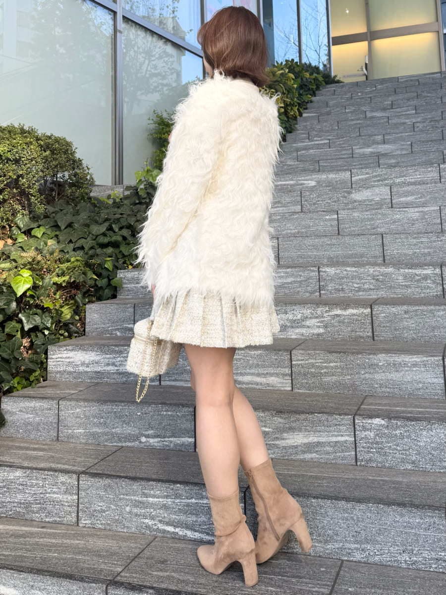 ホワイト系のスカート、ホワイト系のカーディガン/ボレロ、ホワイト系のハンドバッグを着用したレディースの冬コーディネートの5枚目の写真