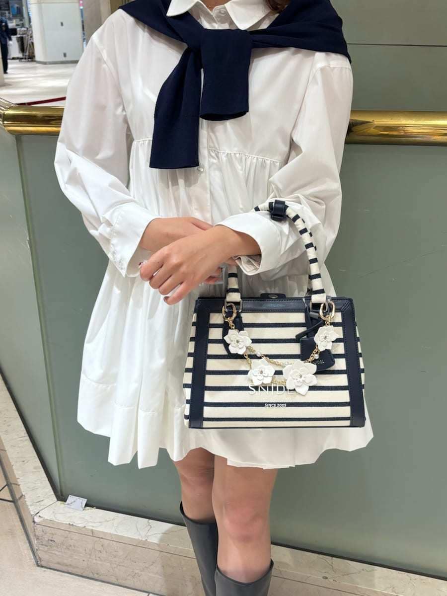 ホワイト系のワンピース、ブルー系のカーディガン/ボレロ、その他のハンドバッグを着用したレディースの春コーディネートの7枚目の写真