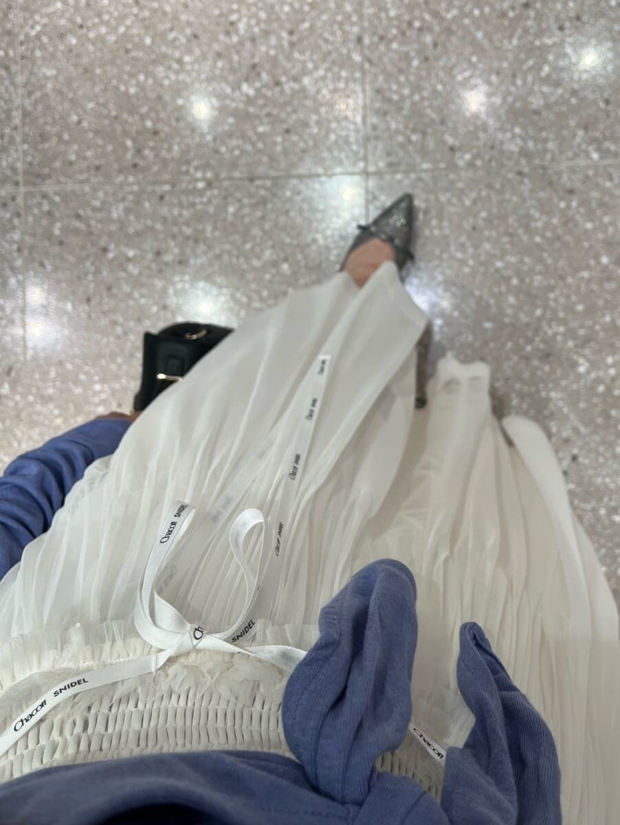 ブルー系のTシャツ/カットソー、ホワイト系のスカート、ブラック系のショルダーバッグを着用したレディースの夏コーディネートの6枚目の写真