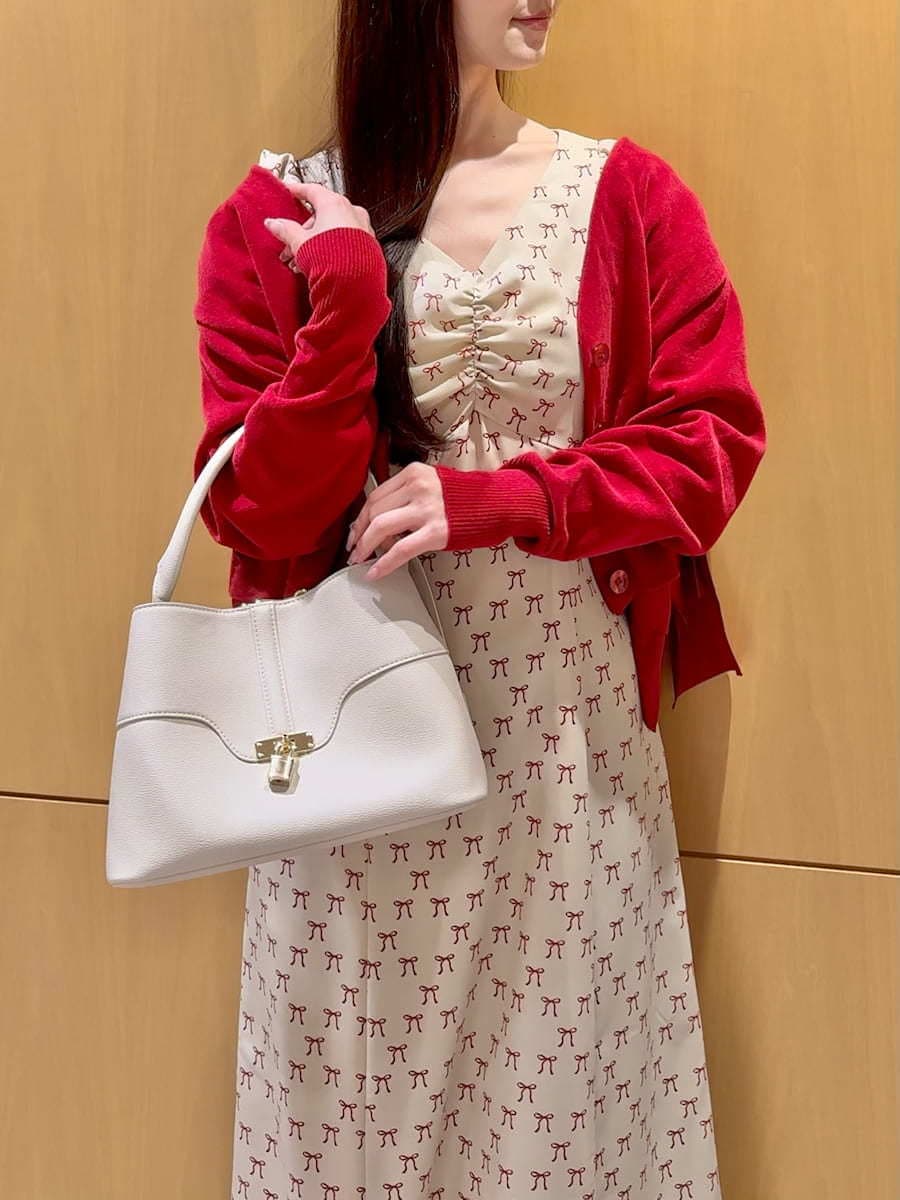 ホワイト系のハンドバッグ、ベージュ系のワンピース、レッド系のカーディガン/ボレロを着用したレディースの冬コーディネートの5枚目の写真