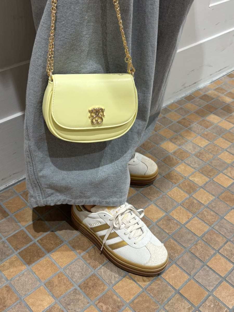 グレー系のデニムパンツ、ホワイト系のシャツ/ブラウス、イエロー系のショルダーバッグを着用したレディースの春コーディネートの7枚目の写真