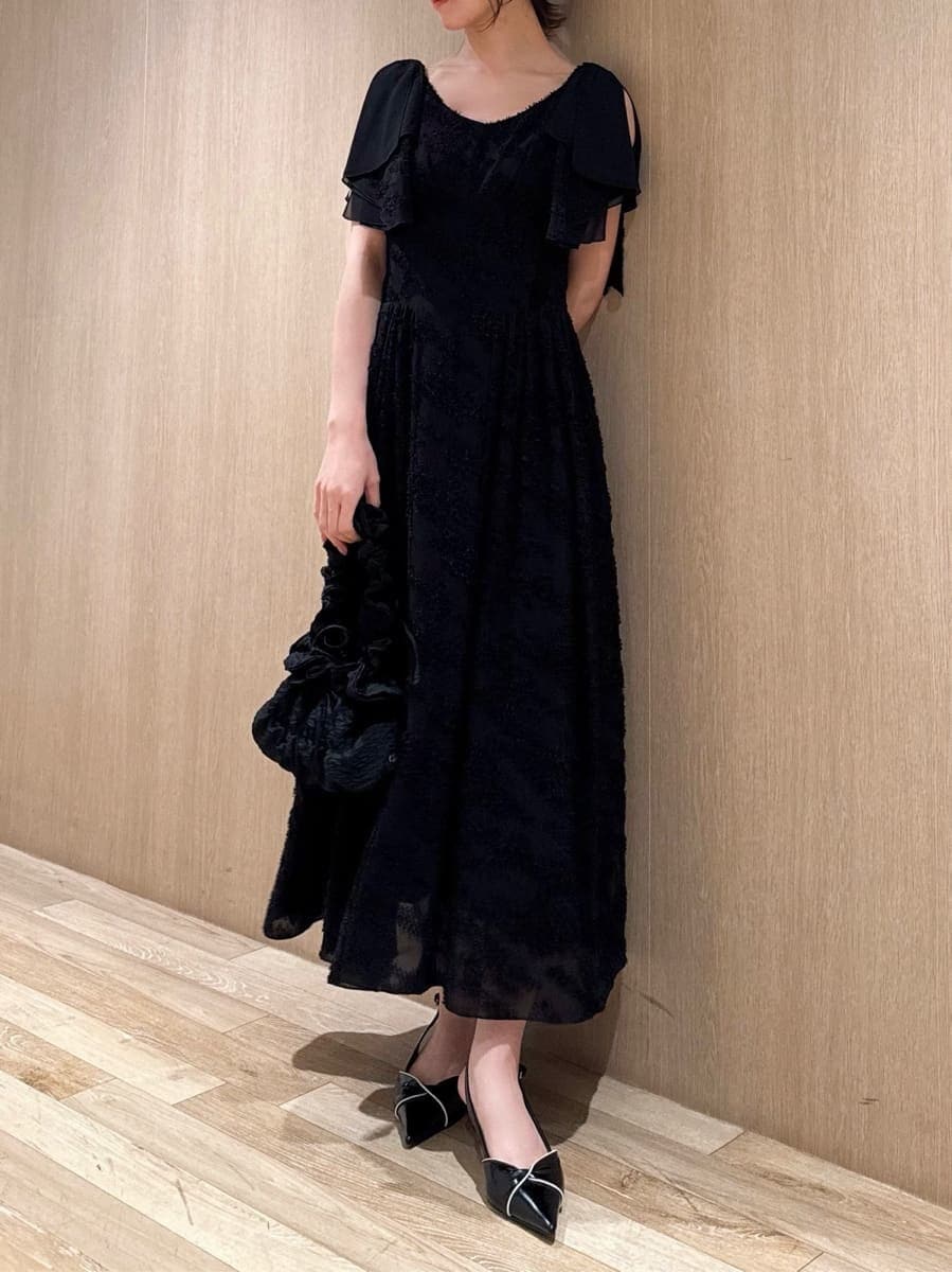 ブラック系のワンピース、ブラック系のパンプスを着用したレディースの春コーディネートの5枚目の写真