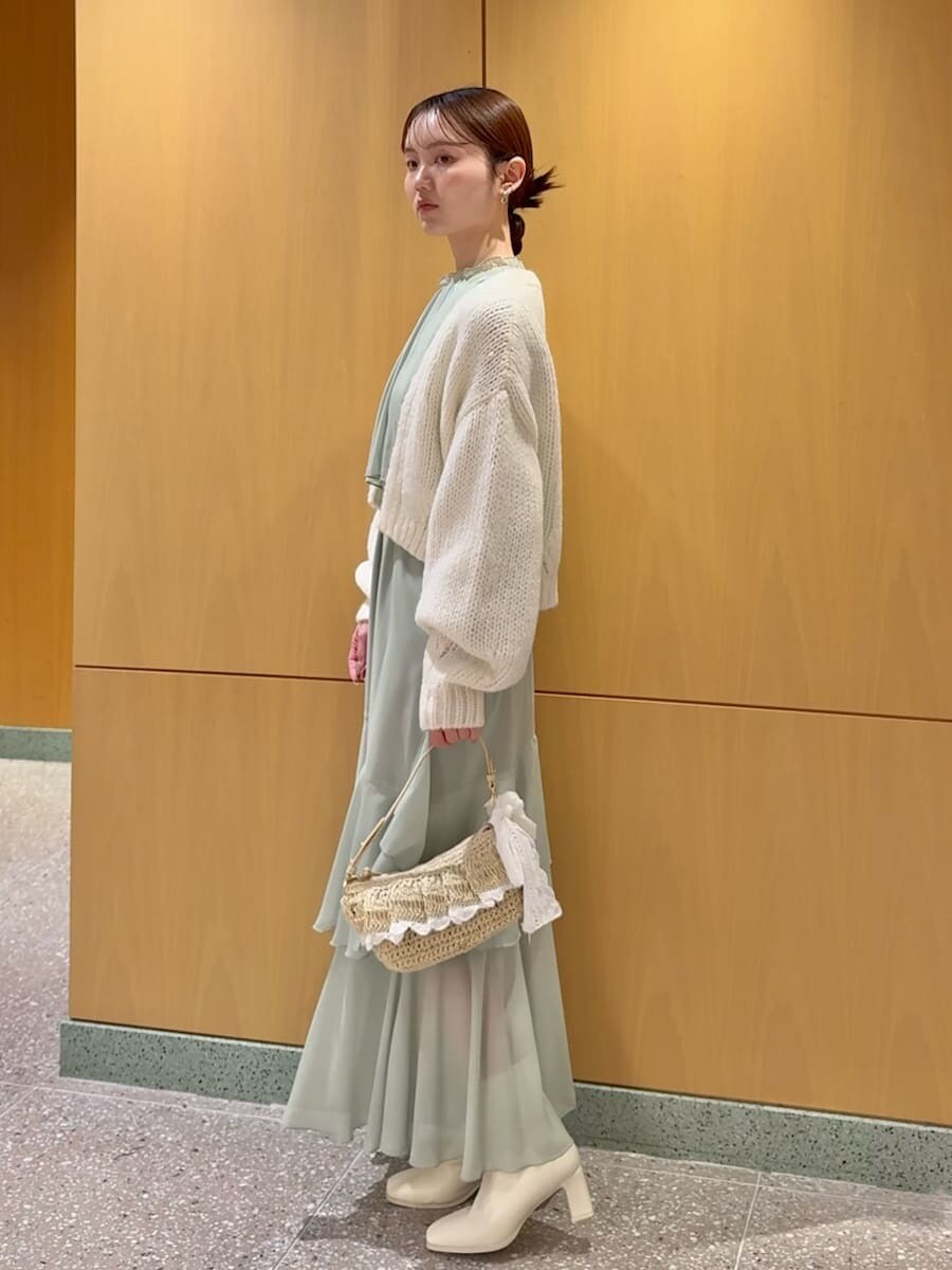 グリーン系のワンピース、ホワイト系のカーディガン/ボレロを着用したレディースの冬コーディネートの2枚目の写真