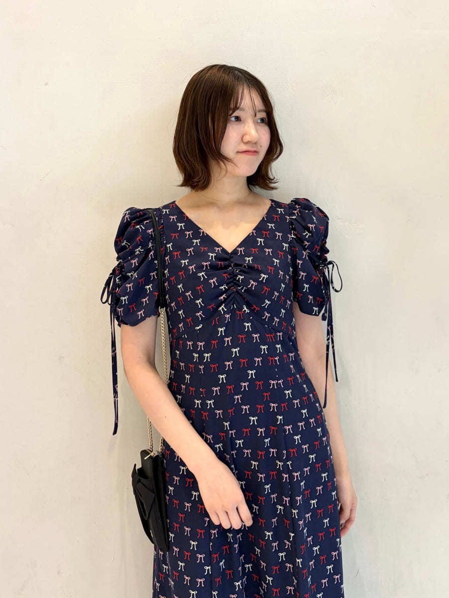 ブルー系のワンピース、ブラック系のパンプス、ブラック系のショルダーバッグを着用したレディースの冬コーディネートの5枚目の写真