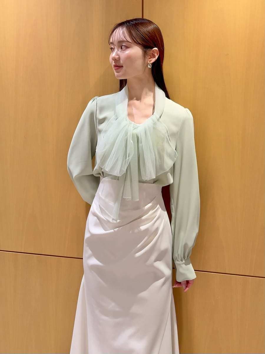 ブラック系のブーツ、ホワイト系のトレンチコート、ホワイト系のスカートを着用したレディースの冬コーディネートの8枚目の写真