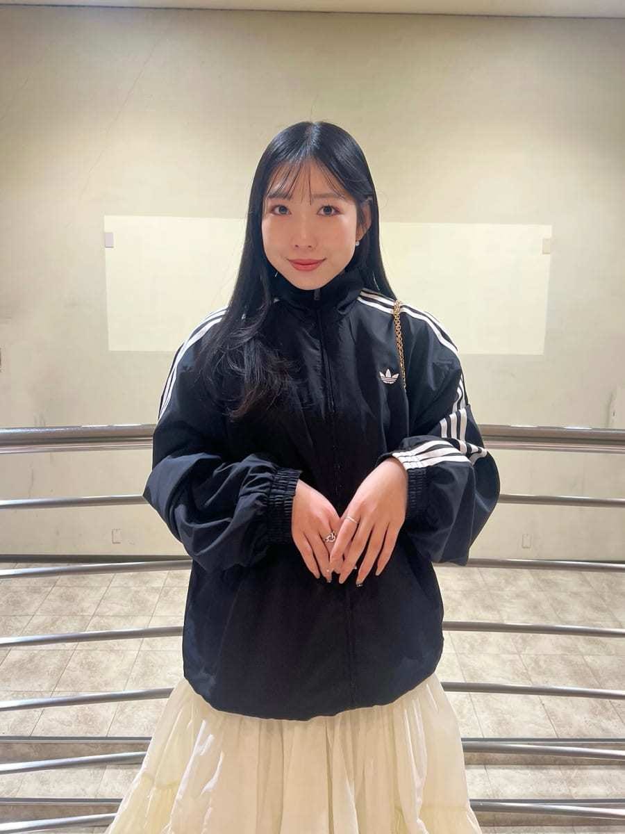 ホワイト系のスカート、ブラック系のブルゾン、イエロー系のパンプスを着用したレディースの春コーディネートの4枚目の写真