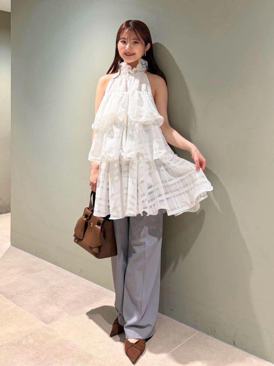 グレー系のスラックス、ホワイト系のワンピース、ブラウン系のパンプスを着用したレディースの春コーディネートの3枚目の写真