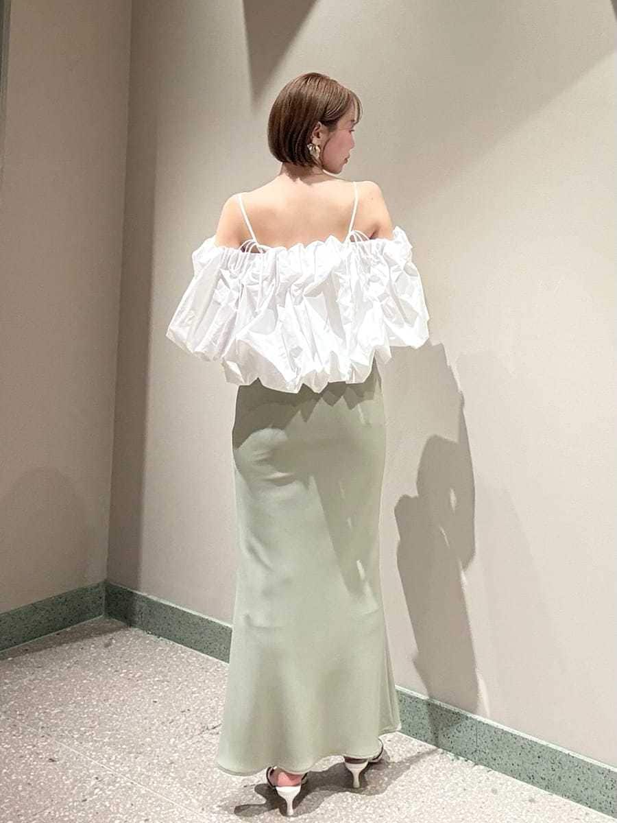 グリーン系のスカート、ホワイト系のシャツ/ブラウス、ホワイト系のハンドバッグを着用したレディースの春コーディネートの9枚目の写真