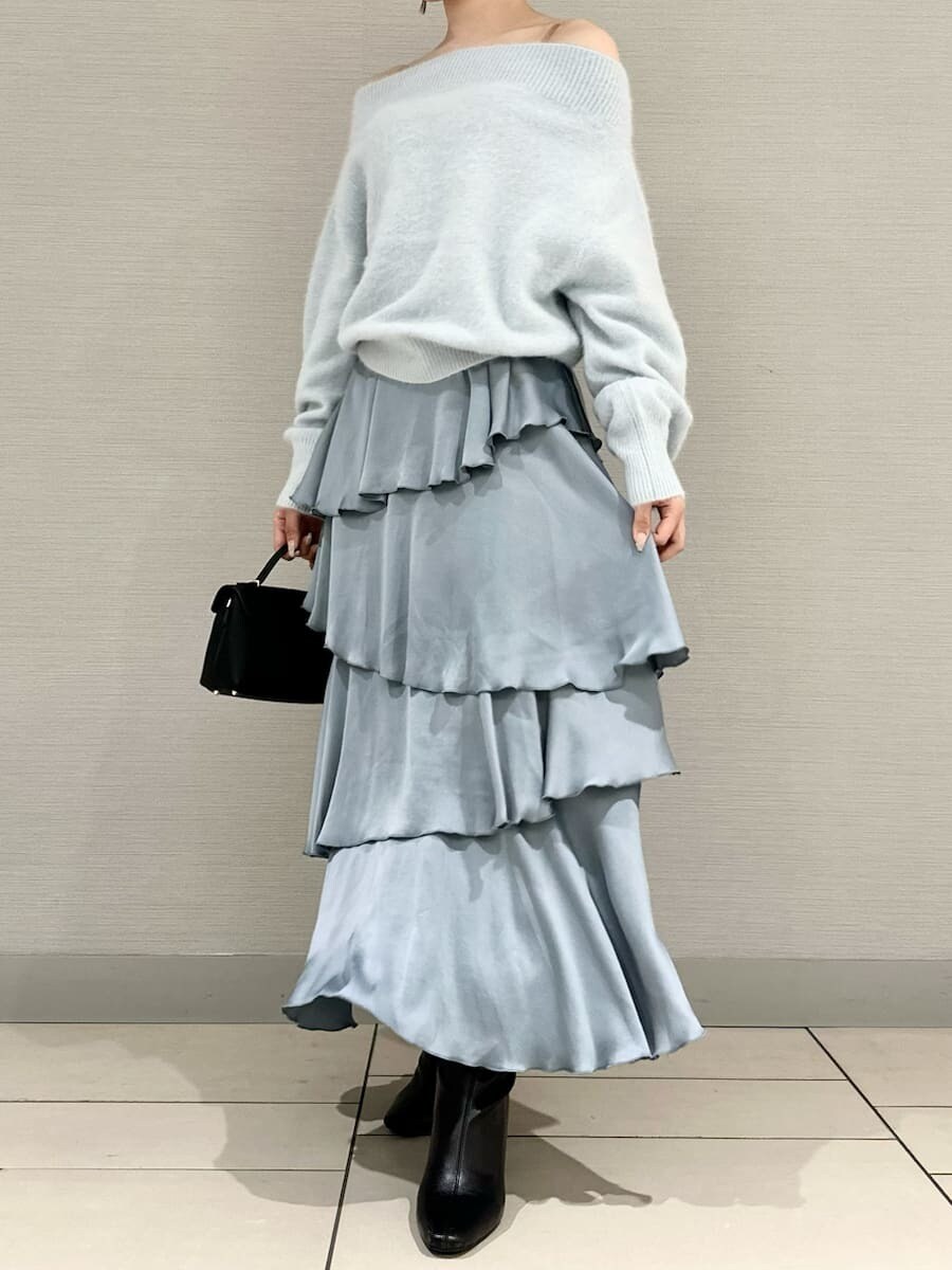 ブルー系のニット/セーター、ブルー系のスカート、ブラック系のブーツを着用したレディースの秋コーディネートの4枚目の写真