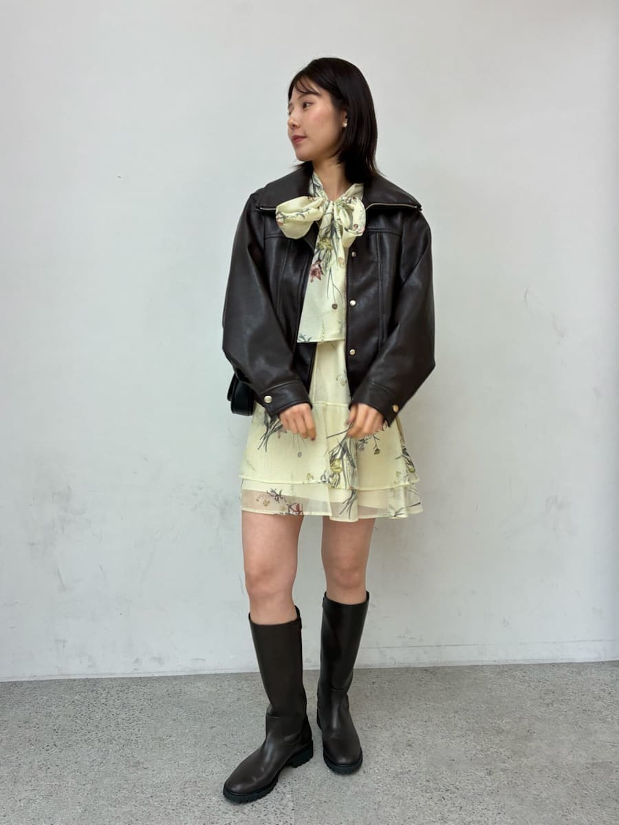 ブラウン系のブルゾン、イエロー系のワンピース、ブラック系のショルダーバッグを着用したレディースの冬コーディネートの2枚目の写真