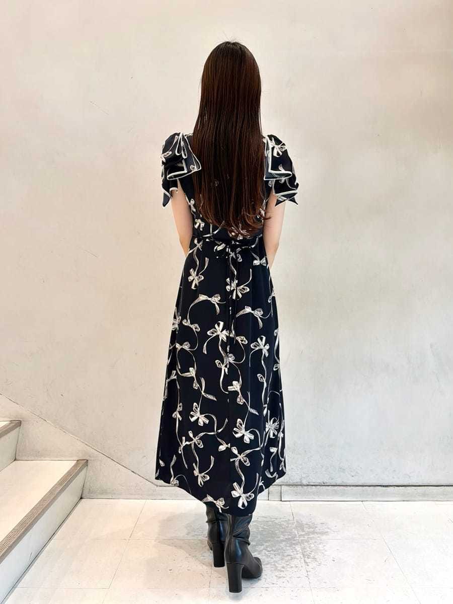 ブルー系のワンピース、ベージュ系のカーディガン/ボレロ、ブラック系のブーツを着用したレディースの秋コーディネートの6枚目の写真